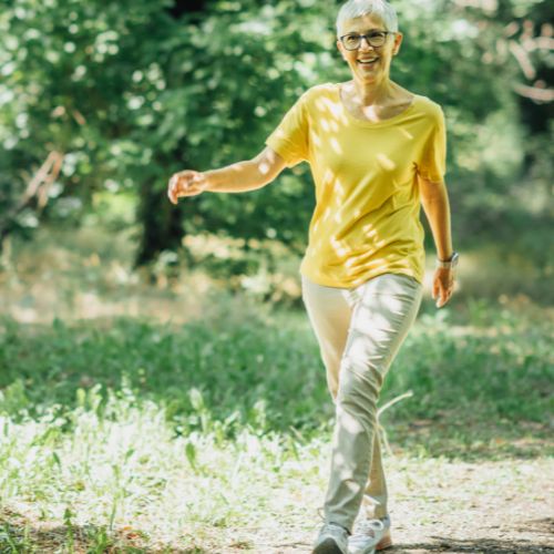 Persona realizando una caminata ligera en un entorno tranquilo como parte de la rehabilitación tras trombosis en la pierna, enfatizando un paso seguro y controlado